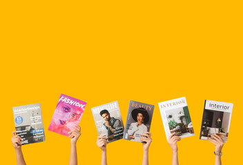 Female hands with different magazines on yellow background