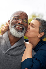 Interracial senior couple, kiss and relax in park, garden or nature for kiss or care together....