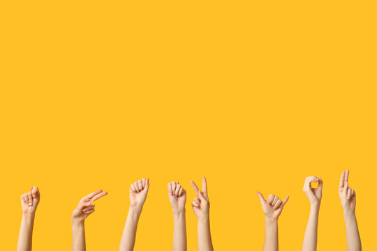 Female hands showing phrase Thank You on yellow background. Sign language