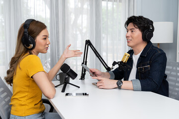 Smiling radio influencer host holding tablet wearing headphones interview woman speaker social media online live streaming channel with talking to share link at morning at studio record. Infobahn.