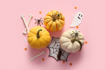 Composition with fresh pumpkins and decorations for Halloween on pink background
