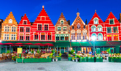 Obraz premium Bruges, Belgium: Night view of the colored houses in the north side of Grote Markt with enchanting street cafes and restaurants, West Flanders