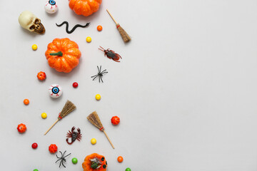 Composition with different decorations and candies for Halloween on grey background