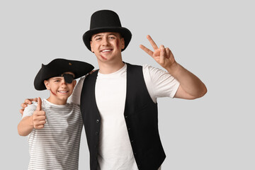 Father with his son dressed for Halloween hugging on light background