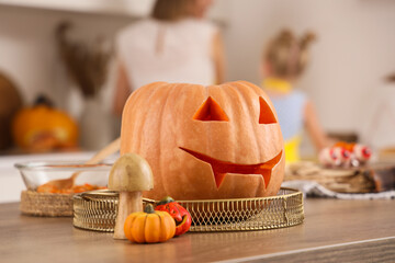 Carved Halloween pumpkin on table in kitchen, closeup