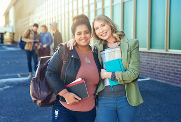 University student, friends and women for hug, portrait or happy with books for learning at campus. Girl, people and smile with embrace, diversity and backpack for education, study or care at college