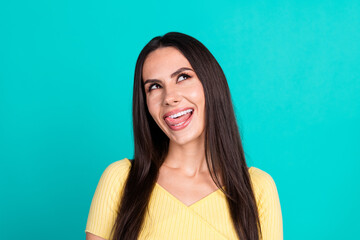Fototapeta premium Photo of nice young woman look empty space lick teeth wear top isolated on teal color background