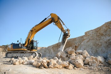 Hydraulic breaker hammer in a quarry for limestone mining with an excavator