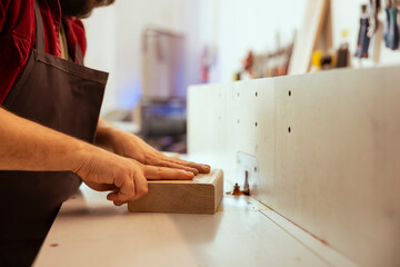Woodworking professional operating wood shaper in assembly shop, creating intricate designs with precision. Cabinetmaker uses spindle moulder to shape and mold wooden pieces, close up shot
