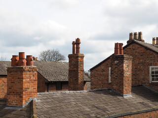 rooftop view of old british brick houses with slate roofs and tall chimneys in Chester