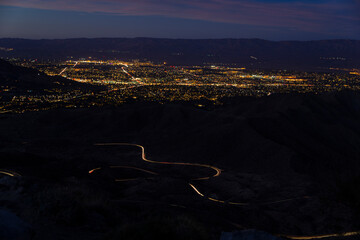 City at night with curvy mountain road long exposure headlights California