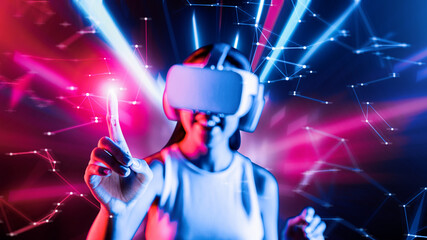 Smart female standing surrounded by neon light wearing VR headset connecting metaverse, future cyberspace community technology. Elegant woman using her finger touching virtual object. Hallucination.