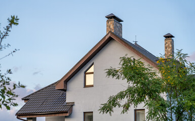 A charming house with unique architectural details, set against a backdrop of gentle evening light and lush trees