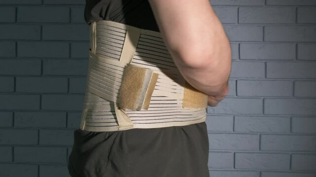 Put posture corrector in pain. A view of patient wearing the posture corrector corset in the room for treatment.