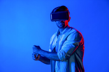 Caucasian man wearing VR glass and moving gesture holding sword. Gamer using future digital virtual reality headset or futuristic innovation to enter meta world or playing action game. Deviation.