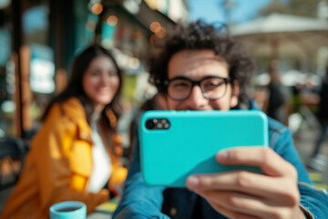 man enjoys a moment taking a selfie with tea as his wife laughs in the background