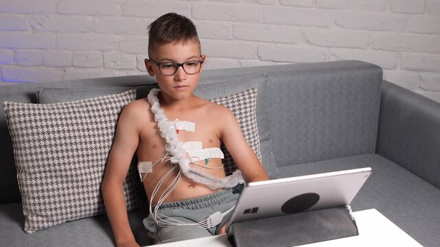 Child patient wearing holter monitor using tablet