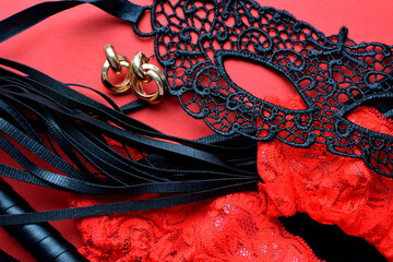 Erotic red stockings, black lace mask and leather whip for sex games. BDSM toys for role-playing...