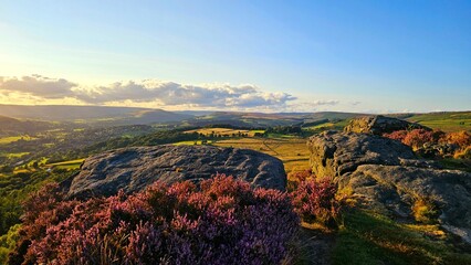 Stunning sunset over Hope Valley from Surprise View, showcasing Millstone Edge and Owler Tor, with vibrant heather in bloom creating a picturesque Peak District landscape. © Papa Bear Explores