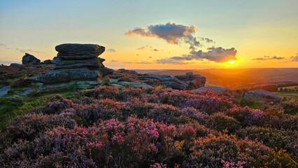 Stunning sunset over Hope Valley from Surprise View, showcasing Millstone Edge and Owler Tor, with vibrant heather in bloom creating a picturesque Peak District landscape.