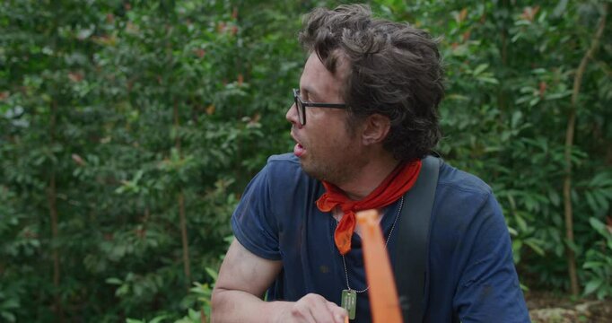 Frightened man with toy bow and arrow turning around and sighing with relief