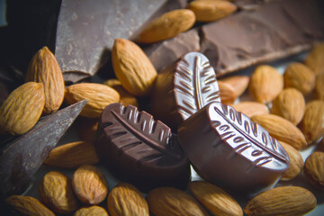 Dark chocolate pieces and almonds, dark photography close-up.