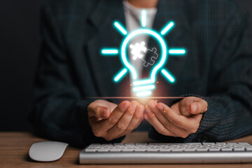 Hands holding a glowing light bulb with a puzzle piece, symbolizing innovative problem-solving and creative solutions in a modern business context.