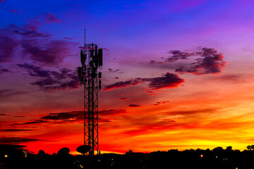 Fototapeta premium Telecommunication towers with colorful sky as a backdrop in the morning and sunlight reflecting off clouds create a stunning and mesmerizing light effect. Concept of innovation, technology and environ