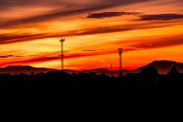 Telecommunication towers with colorful sky as a backdrop in the morning and sunlight reflecting off clouds create a stunning and mesmerizing light effect. Concept of innovation, technology and environ