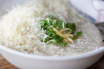 Rice porridge with green onions in white bowl