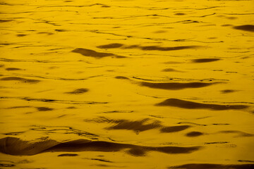 The water is yellow and has ripples