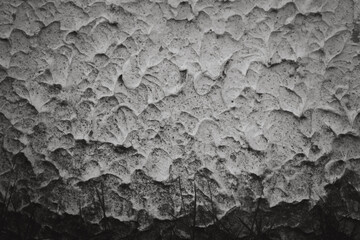 A wall with a textured surface that appears to be made of concrete. The wall has a rough, uneven texture that gives it a rugged, industrial appearance. Scene is one of strength and durability