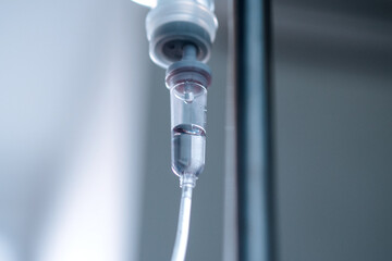 Close up medical intravenous IV drip in hospital background, saline drip