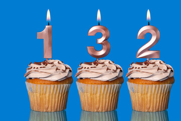 Birthday Cupcakes With Candles Lit Forming The Number 132.
