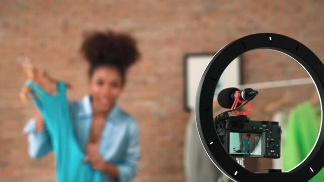Rear view behide camera screen recording woman influencer shoot live stream vlog video review clothe crucial social media or blog. Girl with apparel studio lighting for marketing broadcasting online