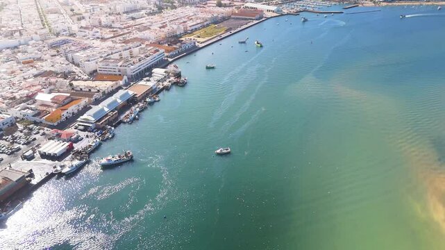 Aerial view of the vibrant port of Isla Cristina with boats and buildings under a clear blue sky, Andalucia, Spain.