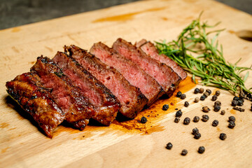 A piece of tenderloin meat is cut into six pieces and is sitting on a wooden cutting board