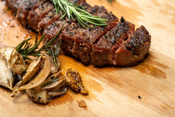 A piece of sirloin meat is cut and sitting on a wooden cutting board