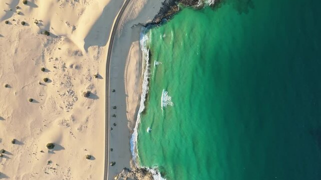 Aerial view of beautiful coastline with sandy beach and tranquil waves, Parque Natural de Corralejo, Fuerteventura, Canary Islands, Spain.