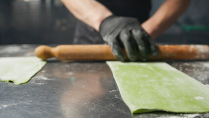 Rolling Pin Over The Flour On Green Dough 