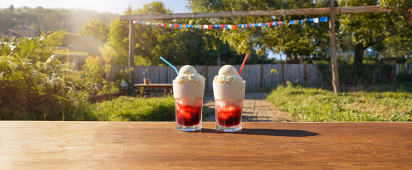 
banner of two glasses of traditional earthquake cocktail on a wooden table outside on a day of September 18, Chile