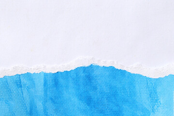 Art paper with blue watercolors on the white art paper and torn overlapping.