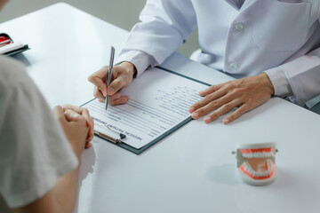 A dentist advises a patient on dental care in a modern clinic, explaining oral hygiene and treatment options with tools or diagrams.