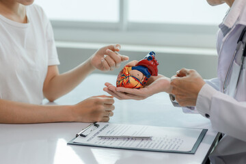 Fototapeta premium A doctor consults a patient on heart disease, explaining treatment options in a calm, professional setting.
