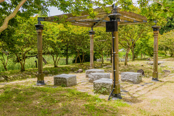 Stone carved benches underneath wooden gazebo in nature park located in Hampyeong, South Korea.
