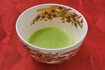 日本の茶道　茶碗と抹茶　 赤背景　コピースペースあり　Japanese Tea Ceremony (Chado) : Tea bowl and matcha (green tea) on red background, copy space available