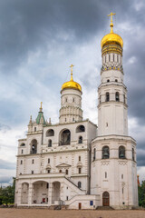 Ivan the Great Bell Tower, with Assumption Belfry on the right in Moscow Kremlin. Blue sky background with sunbeams