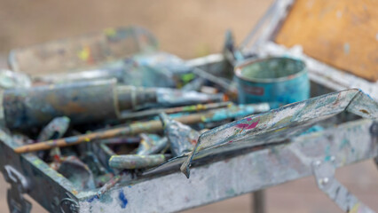 A messy art supplies tray with a variety of colors and tools