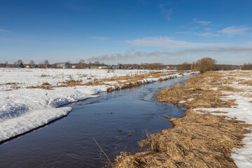 A river with a lot of snow on the banks