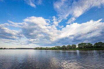 A calm lake with a cloudy sky in the background